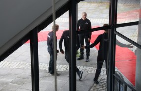 Lasiovien edess ovimiehiä, taustalla punainen matto.