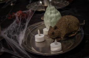 Halloween-pakohuoneen rekvisiittaa: leikkihiiri, kynttilöitä ja hämähäkinseittiä