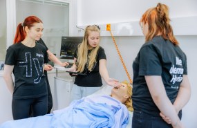 Lähihoitajaopiskelijat hoitoluokassa hoitamassa hoitonukkea.