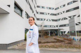 Valkotakkinen lääkäri ulkona sairaalarakennuksen sisäpihalla