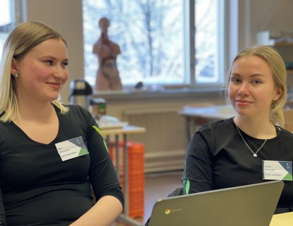 Taitaja-semifinalistit 2022 Sini Vihavainen (vas.) ja Jenna Vuorisalo istuvat luokassa tietokoneen äärellä.