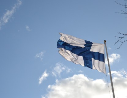 Suomen lippu liehuu taivasta vastan