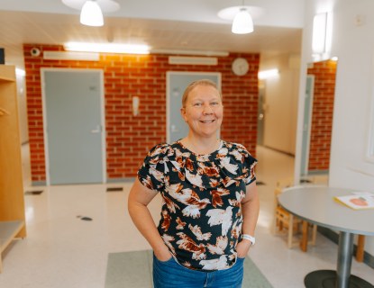 Hymyilevä nainen työpaikkansa aulatilassa