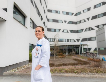 Valkotakkinen lääkäri ulkona sairaalarakennuksen sisäpihalla
